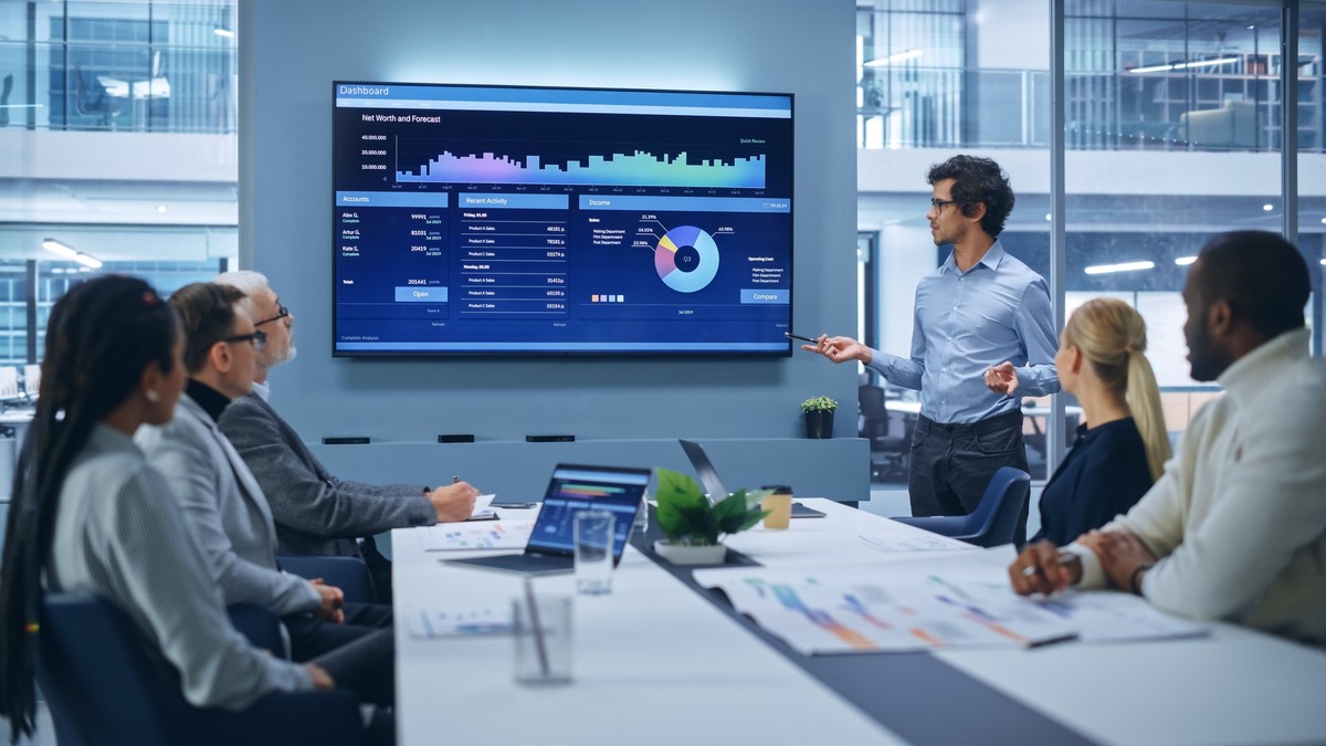 Business team meeting around analytics dashboard with charts