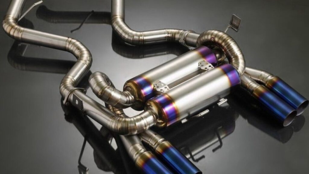 Stainless steel exhaust system with polished pipes and mufflers with blue burnt tips on a dark background